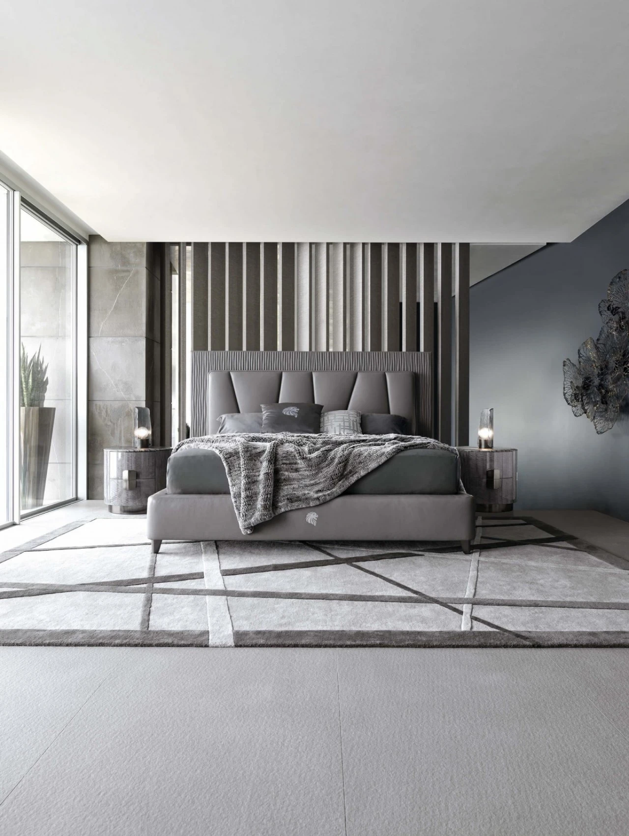 Bedroom with a quilted grey bed against a slatted wall, from luxury furniture companies