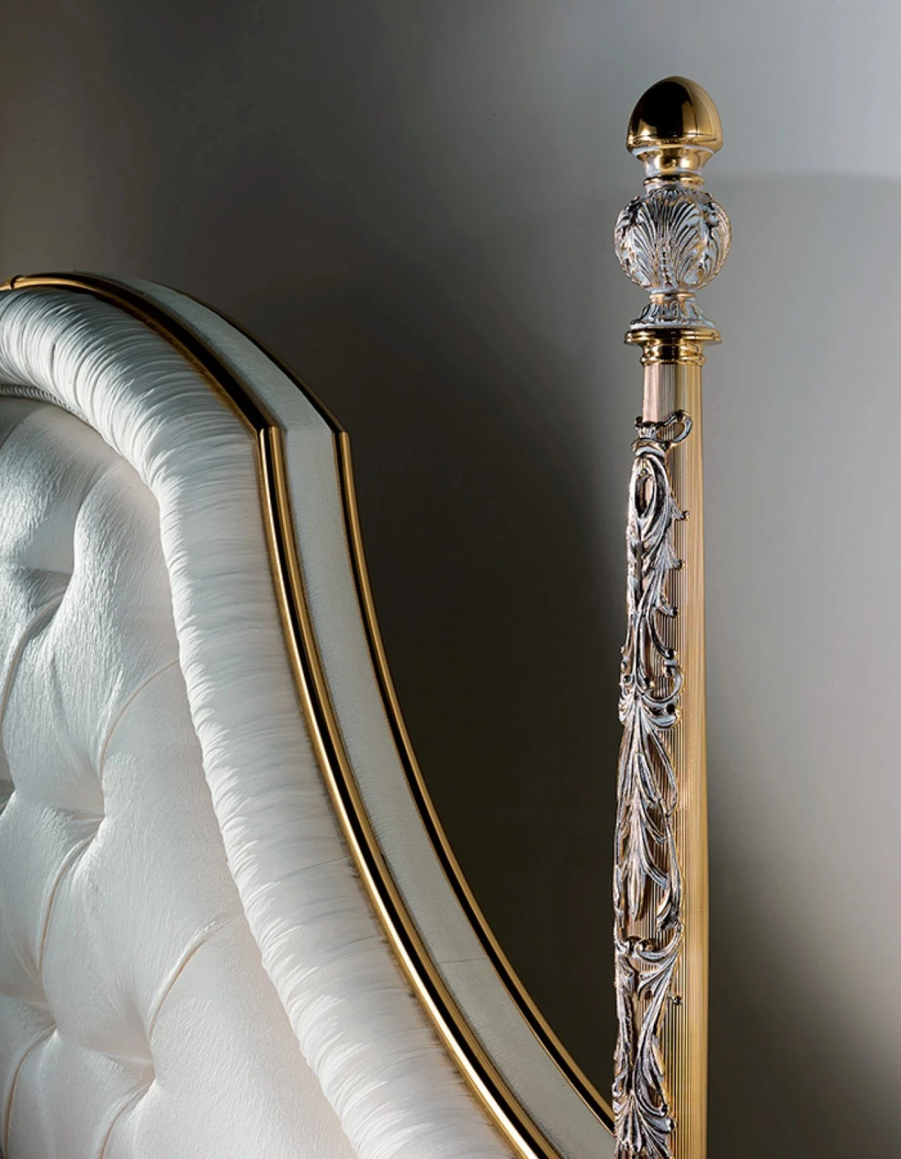 Ivory capitonné headboard beside a gilded post with a crystal finial, luxury living furniture